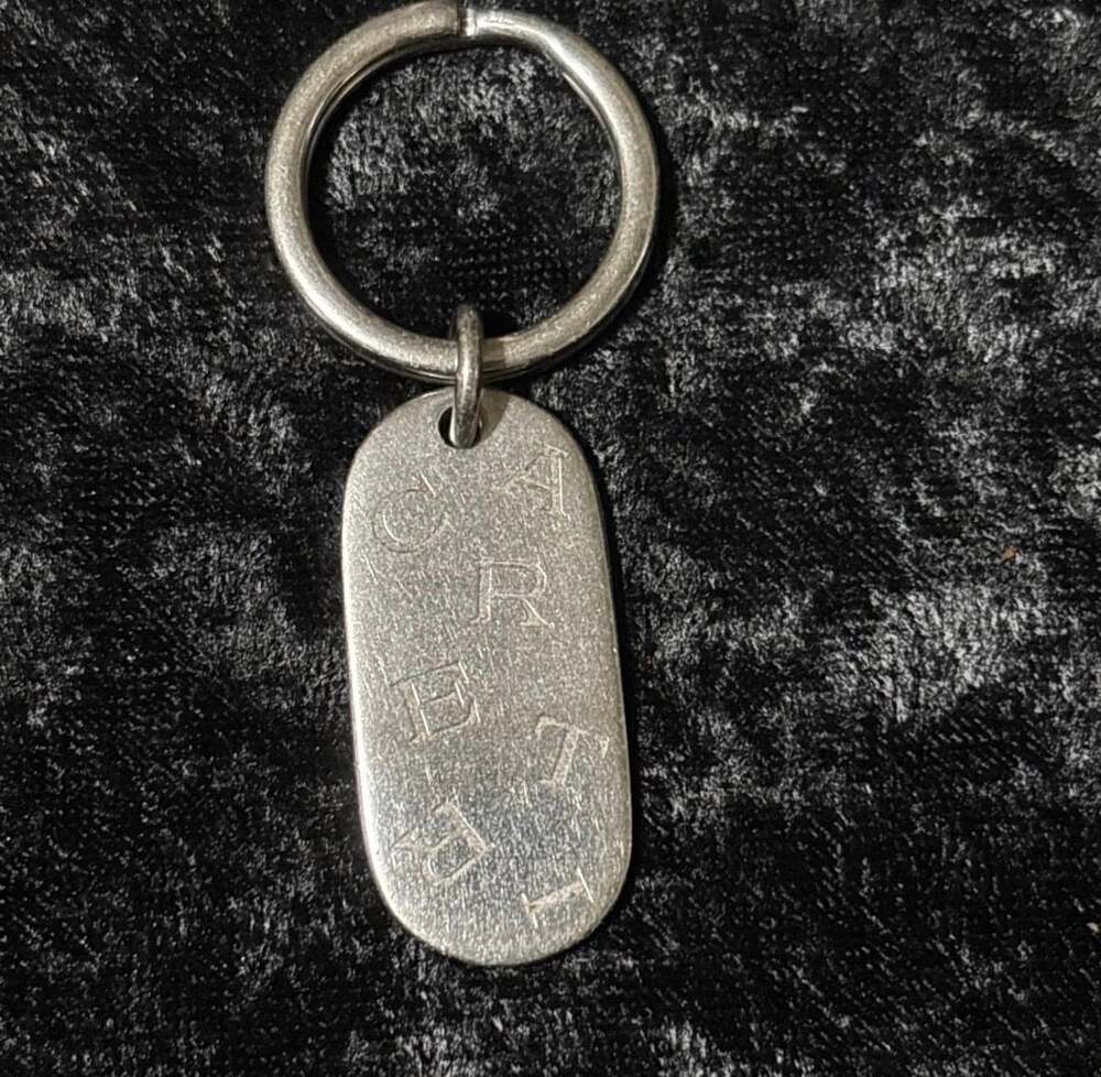 Cartier Silver Steel Scattered Logo Oval Keychain.